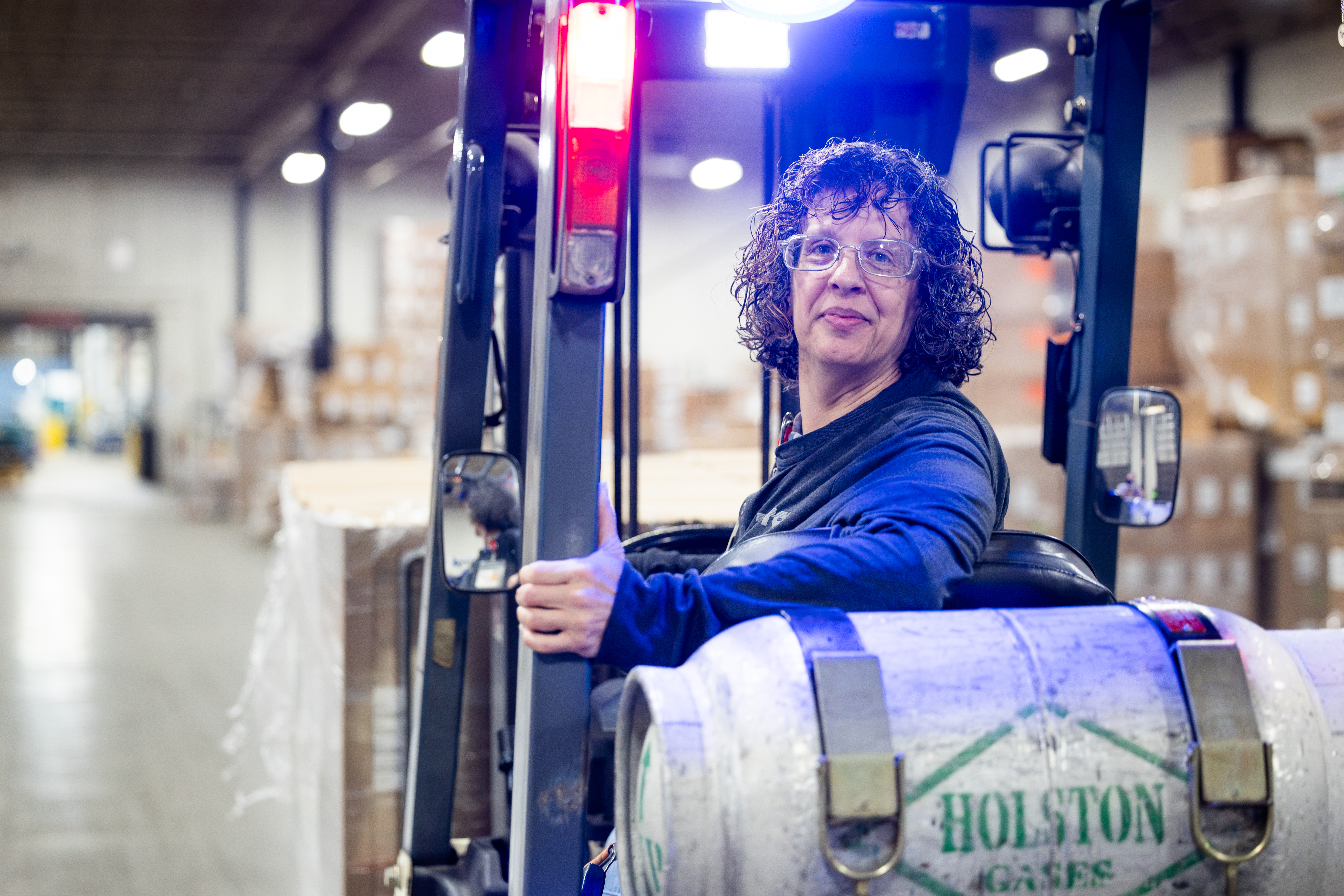 Person With Curly Hair Sitting On Fork Lift