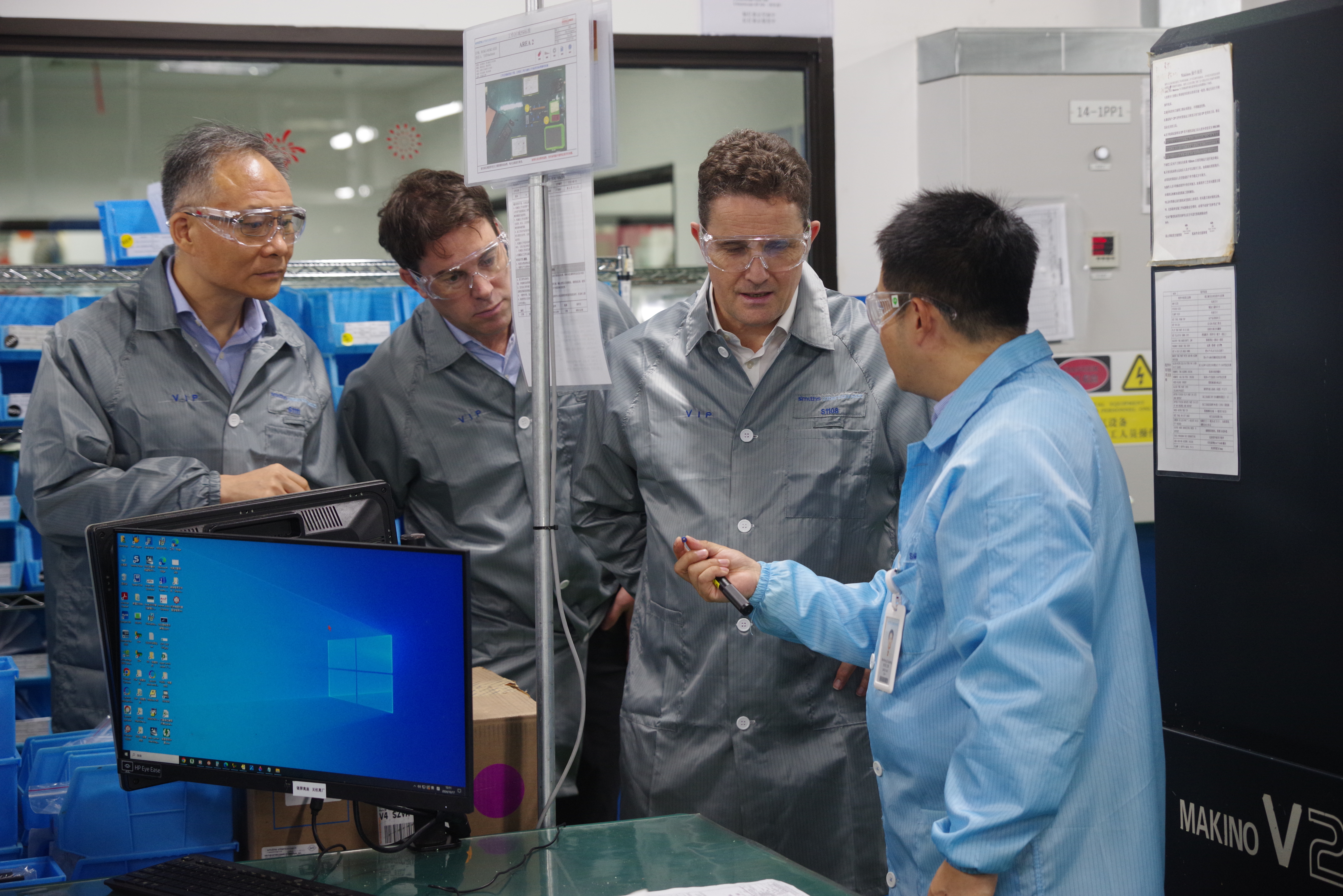 Four People Looking At Tool