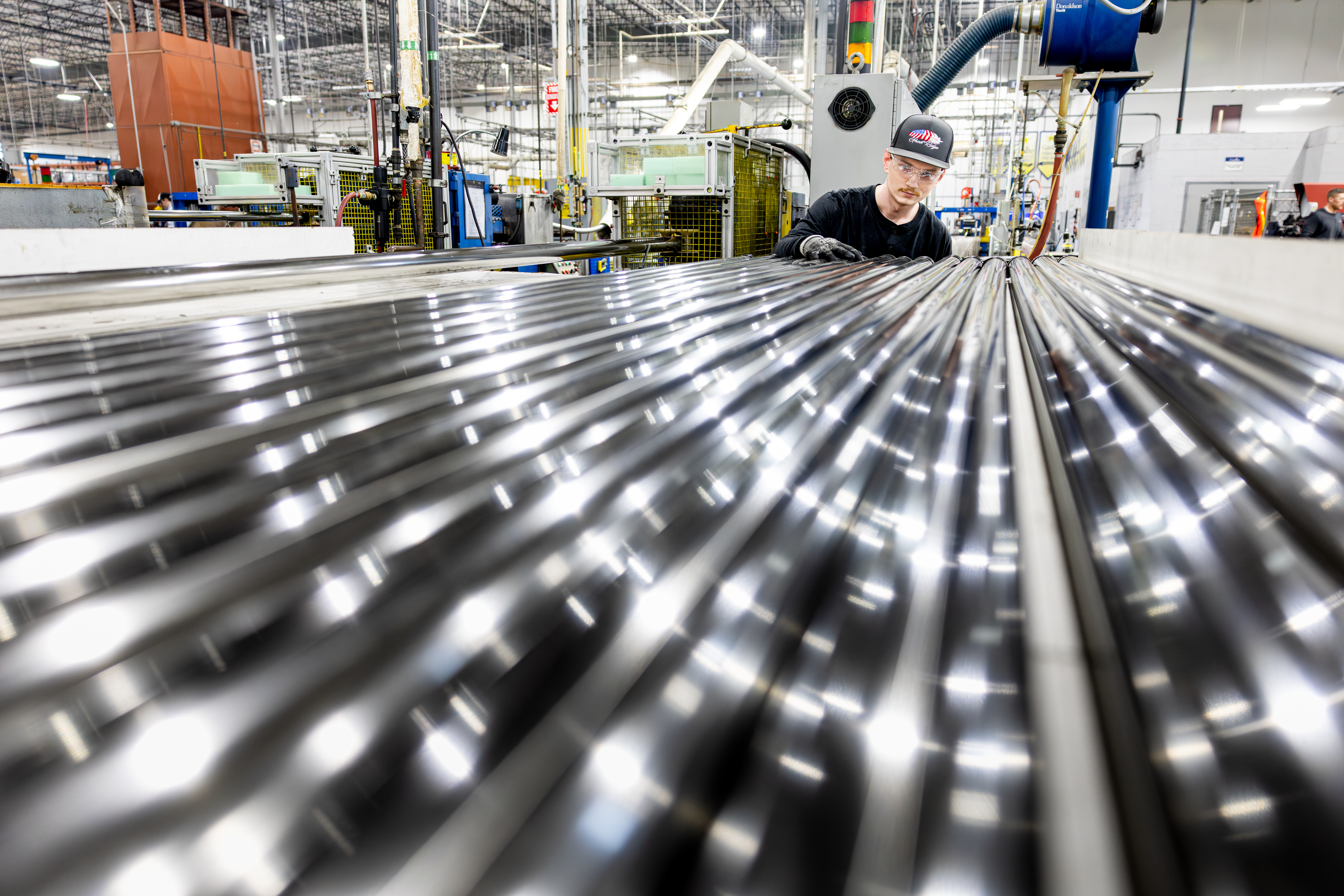 Man Wearing Safety Glasses And Gloves Inspecting Product